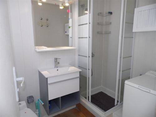 une salle de bain blanche avec une douche et un lavabo dans l'établissement Duplex climatisé avec 2 chambres, grande terrasse et parking privé - FR-1-326-611, à Marseillan