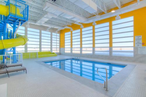 a large swimming pool with a slide in a building at Holiday Inn Express & Suites - Moose Jaw, an IHG Hotel in Moose Jaw