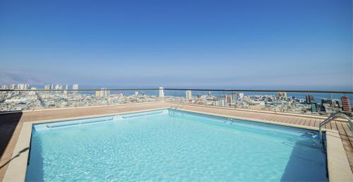 a swimming pool on top of a building with a beach at Departamento Iquique Nuevo Centro in Iquique