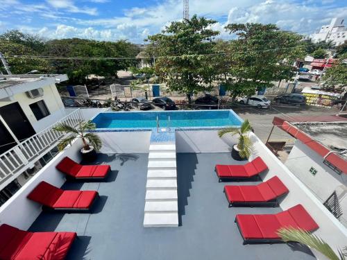 a view of a swimming pool with red lounge chairs at BALAM Playa - 15Th Ave in Playa del Carmen