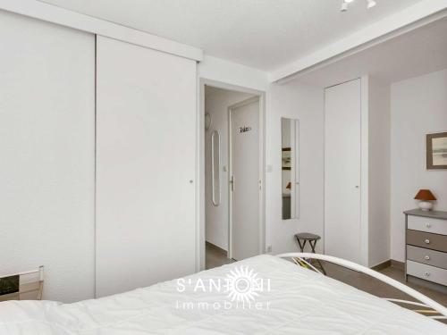 - une chambre avec des murs blancs et un lit blanc dans l'établissement Bel appartement 2 pièces climatisé RDC avec terrasse et stationnement, Le Grau d'Agde - FR-1-423-63, au Grau-dʼAgde