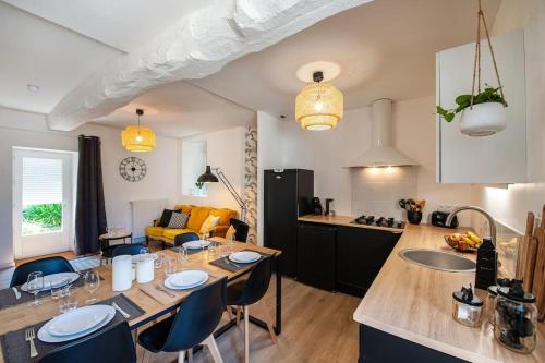 a kitchen and living room with a table and chairs at Duplex contemporain dans maison du XVIIème siècle in Fougères
