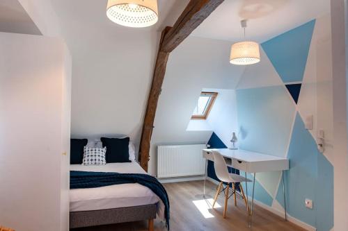 a small bedroom with a bed and a desk at Duplex contemporain dans maison du XVIIème siècle in Fougères