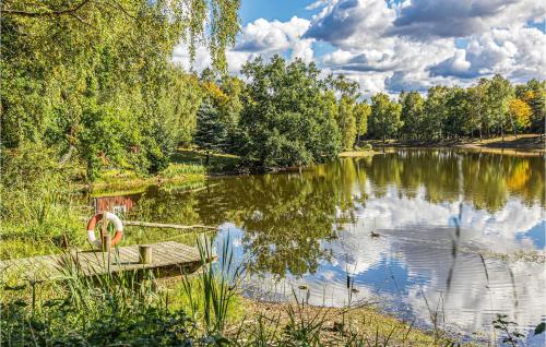 a view of a lake with a bench and trees at Lovely Home In Munka-Ljungby With Wifi in Munka-Ljungby