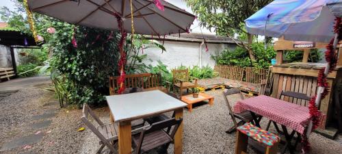 tavolo e sedie con tavolo e ombrellone di Amares Hostel a Florianópolis