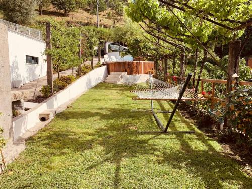 a yard with a hammock in the grass at Casas D'Aldeia Arcos de Valdevez in Arcos de Valdevez
