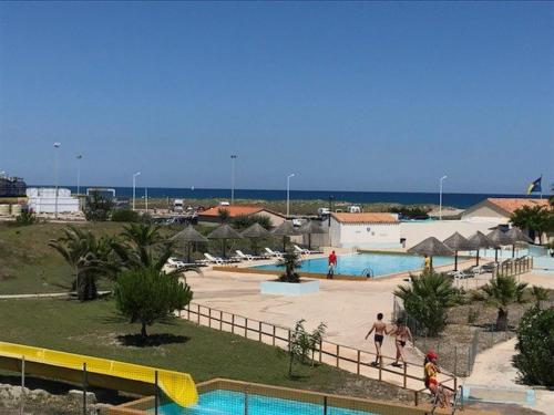 un groupe de personnes jouant dans une piscine dans l'établissement Studio cabine face mer avec parking privé, proche commerces et plage - FR-1-81-463, à Port-Leucate