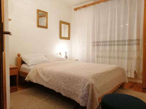 a bedroom with a bed and a window at PLITVICE KONAK Daic in Plitvička Jezera