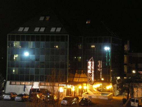 a building at night with cars parked in a parking lot at Hotel & Loisir Le Ruote in Roveleto