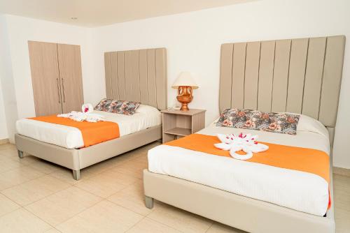 - une chambre avec 2 lits et une lampe au sol carrelé dans l'établissement Hotel Palma Real, à Sambo Creek