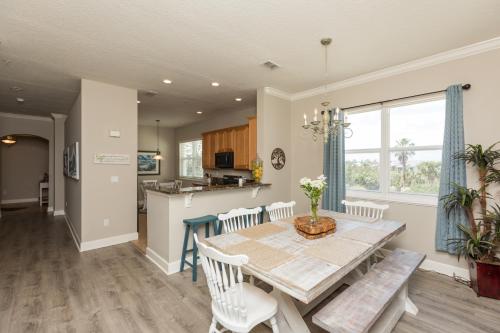 a kitchen and dining room with a table and chairs at SouthernVilla Ticket to Paradise in Palm Coast