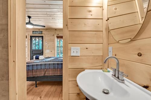 La salle de bains est pourvue d'un lavabo et d'un lit dans la chambre. dans l'établissement Tillies Stall - Queen Studio - private 36-acre resort with 6 homes amazing waterfall, à Cosby