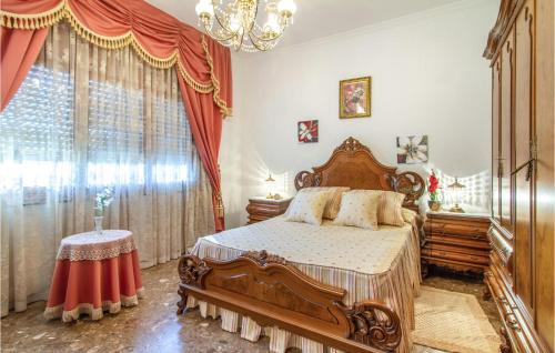 4 Bedroom Beautiful Home In Lorca في لوركا: غرفة نوم بسرير خشبي وثريا