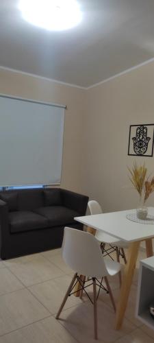 sala de estar con mesa blanca y sofá negro en Caseros en General Alvear