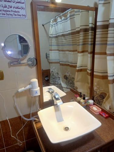 a bathroom with a white sink and a shower at فاكانزا شقة فندقية مفروشة- vacanze in Fayoum Center