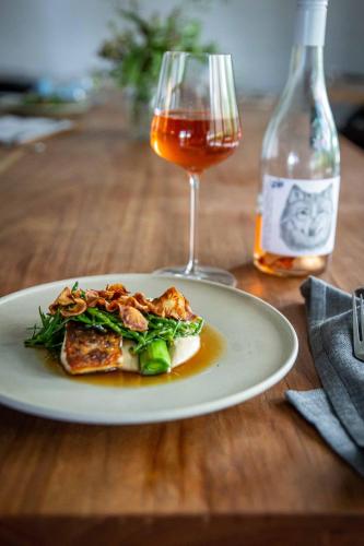 a plate of food and a glass of wine on a table at Bangalay Luxury Villas in Shoalhaven Heads