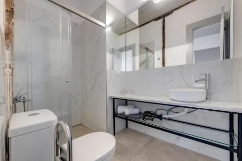 Un baño blanco con lavabo e inodoro. en The Ten Syros, en Ermoupoli