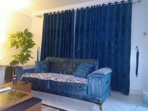 a blue couch in a living room with a blue curtain at فاكانزا شقة فندقية مفروشة- vacanze in Fayoum Center