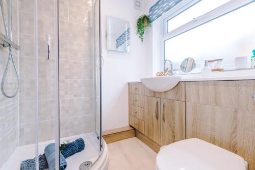 uma casa de banho com um chuveiro, um WC e um lavatório. em Stunning 3-bed home in Nantwich by 53 Degrees Property - Amazing location, Ideal for Groups - Sleeps 6 em Nantwich