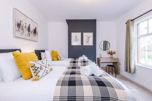 a white bedroom with two beds with yellow pillows at Stunning 3-bed home in Nantwich by 53 Degrees Property - Amazing location, Ideal for Groups - Sleeps 6 in Nantwich