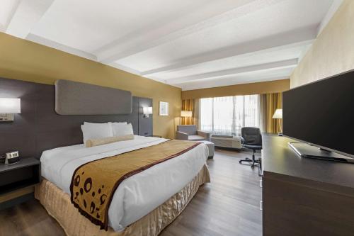 マディソンにあるBest Western Plus Madison-Huntsville Hotelのベッド1台、薄型テレビが備わるホテルルームです。