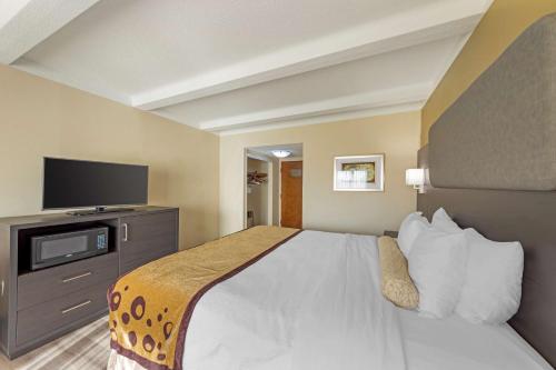 a hotel room with a bed and a flat screen tv at Best Western Plus Madison-Huntsville Hotel in Madison