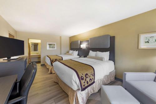 a hotel room with two beds and a flat screen tv at Best Western Plus Madison-Huntsville Hotel in Madison
