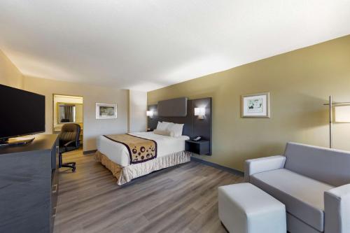 a hotel room with a bed and a flat screen tv at Best Western Plus Madison-Huntsville Hotel in Madison