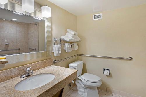 a bathroom with a toilet and a sink and a mirror at Best Western Plus Madison-Huntsville Hotel in Madison