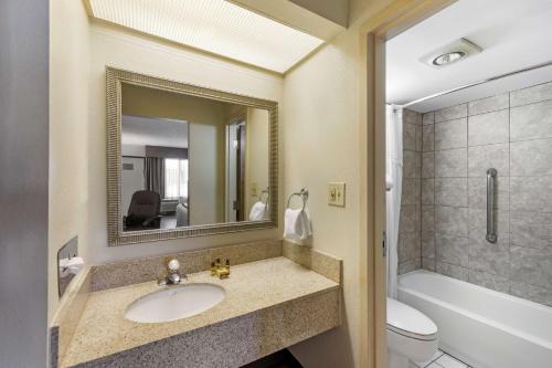 a bathroom with a sink and a toilet and a mirror at Best Western Plus Madison-Huntsville Hotel in Madison