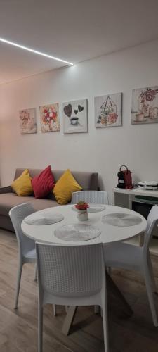 a table and chairs in a living room with a couch at Adele's Apartment in Bissone