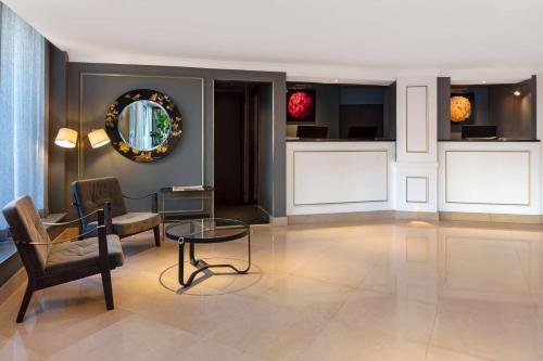 a living room with a chair and a table at Radisson Blu Hotel, London Bond Street in London