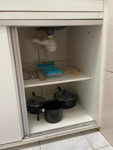 two pots and pans on a shelf in a kitchen at Studio Copacabana Ipanema in Rio de Janeiro