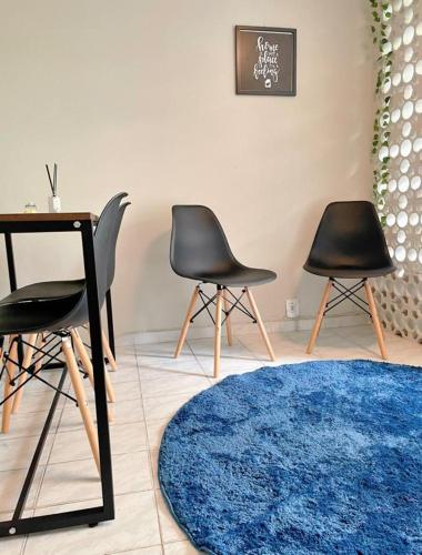 a room with three chairs and a table and a blue rug at Studio Copacabana Ipanema in Rio de Janeiro