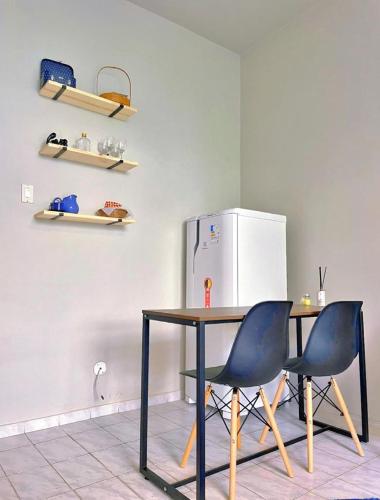 a kitchen with a table and two chairs and a refrigerator at Studio Copacabana Ipanema in Rio de Janeiro