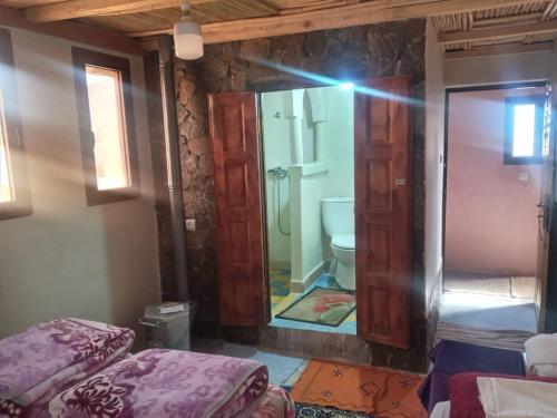 a bathroom with a toilet and a mirror at Auberge des lacs in Imilchil