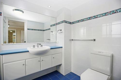 a white bathroom with a sink and a mirror at Aquarius Apartment 4 in Hawks Nest