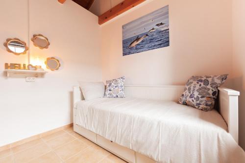 a bedroom with a bed and a picture on the wall at Cantinho do Sossego in Madalena