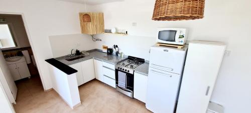 a small kitchen with a white refrigerator and a microwave at MUNA in Concepción del Uruguay