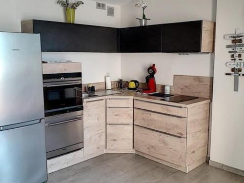 une cuisine avec des appareils en acier inoxydable et des armoires en bois dans l'établissement Studio rénové avec climatisation et piscine à Bormes-les-Mimosas - FR-1-610-63, à Bormes-les-Mimosas