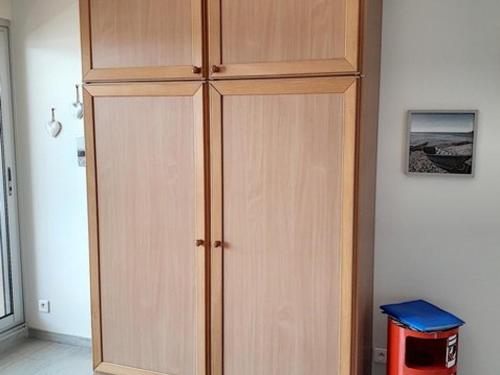 d'une grande armoire en bois dans l'angle de la pièce. dans l'établissement Studio rénové avec climatisation et piscine à Bormes-les-Mimosas - FR-1-610-63, à Bormes-les-Mimosas