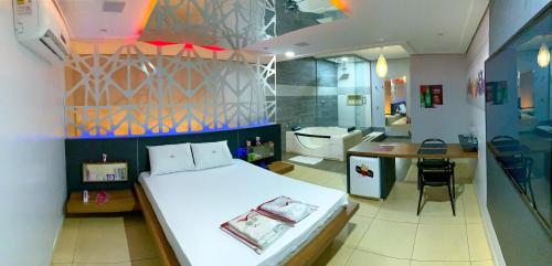 a bedroom with a large bed and a bathroom at Rodotel Vênus Prime in Rio Verde
