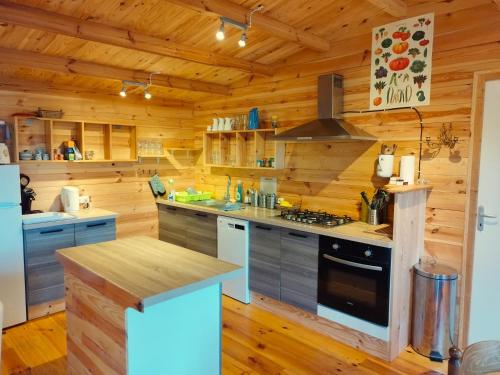 a large kitchen with wooden walls and wooden floors at Ferme de la Luciole in Champs Sur Tarentaine