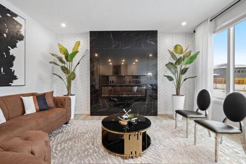 a living room with a couch and a table at Luxury-4bed with AC-86"TV-BrandNew in Cranston, Calgary in Calgary