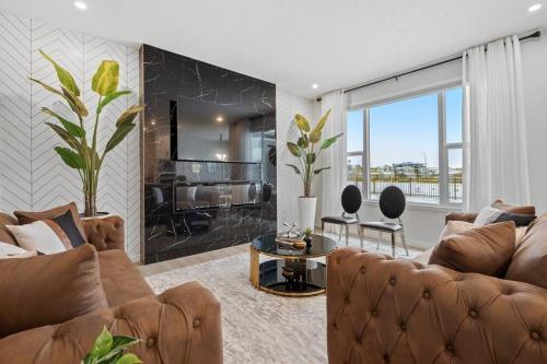 a living room with a couch and a table at Luxury-4bed with AC-86"TV-BrandNew in Cranston, Calgary in Calgary
