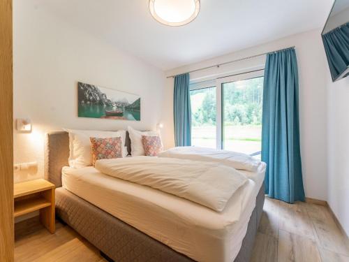 - une chambre avec un lit et une grande fenêtre dans l'établissement Wieserwald, à Wald im Pinzgau