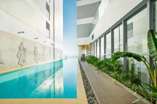an external view of a building with a swimming pool at Homie Panorama Beachfront Residences Nha Trang in Nha Trang