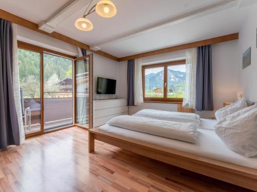 um quarto com uma cama grande e uma janela grande em Haus Wald em Wald im Pinzgau