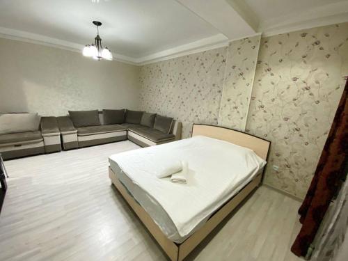 uma sala de estar com uma cama e um sofá em apartment near Cosmopark complex em Bishkek