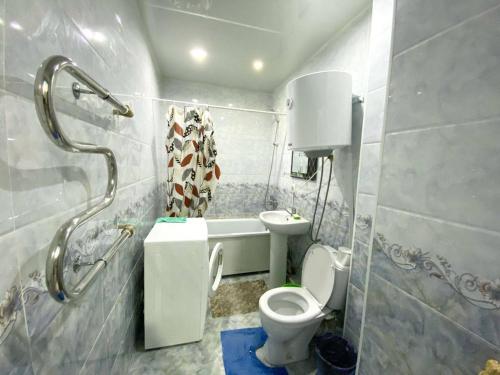 uma casa de banho com um WC, um lavatório e um chuveiro em apartment near Cosmopark complex em Bishkek